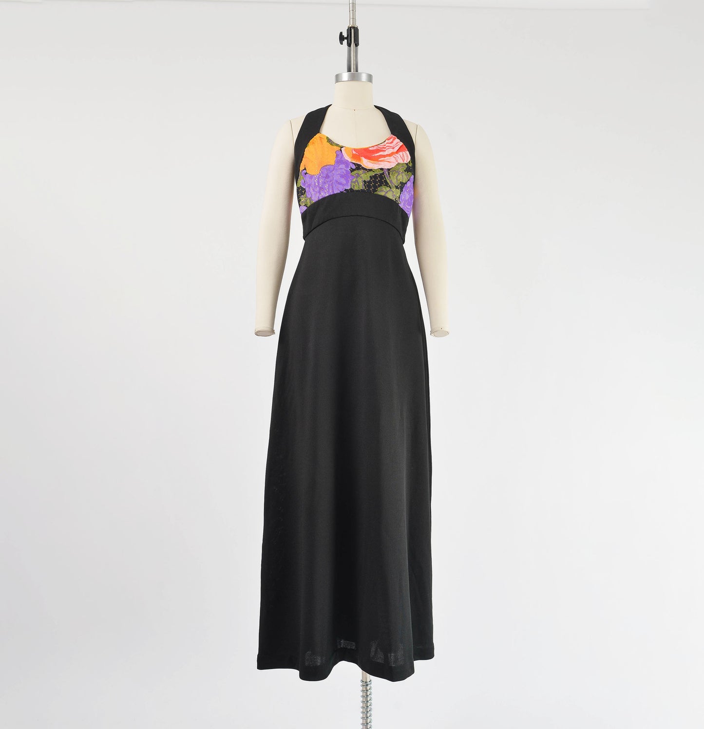Full length view 1970s black floral knit maxi dress. Empire waist with full a-line silhouette.