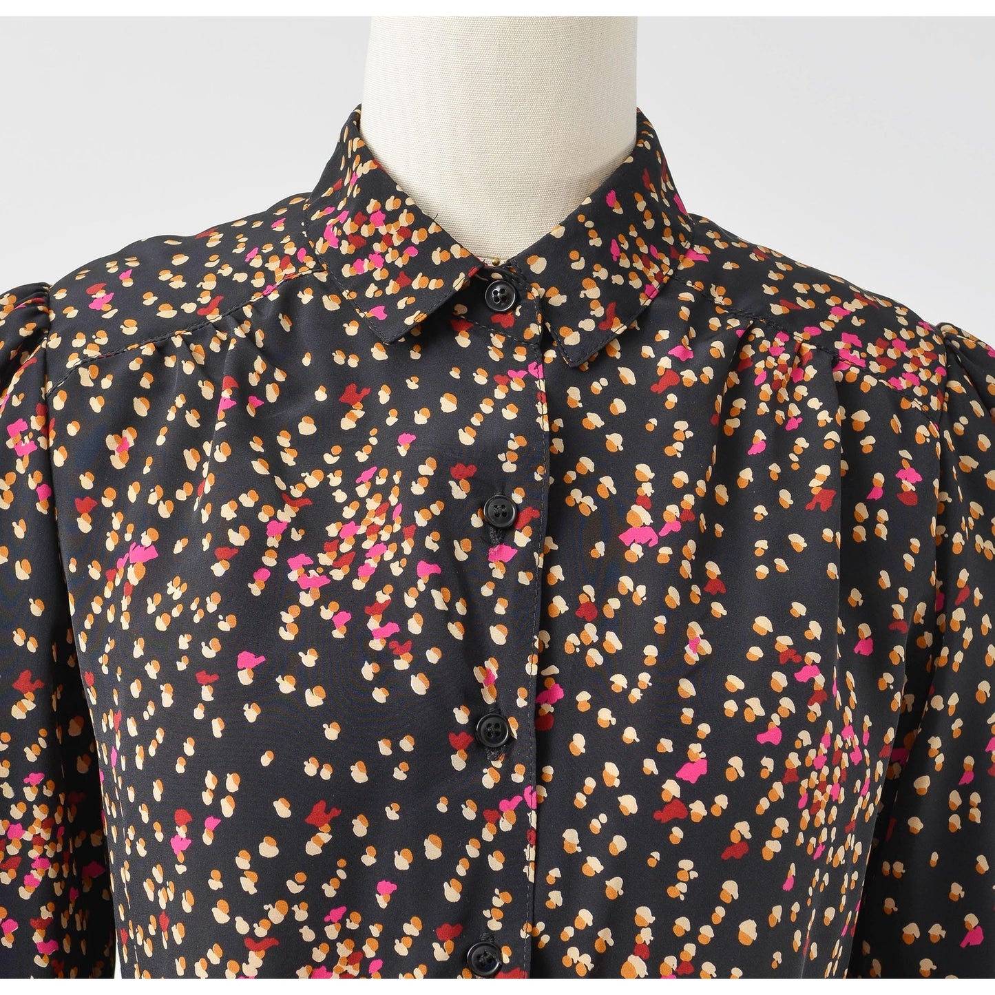 View of collar on 70s black spotted blouse. Matte silky fabric. Collared neckline with long puff sleeves.