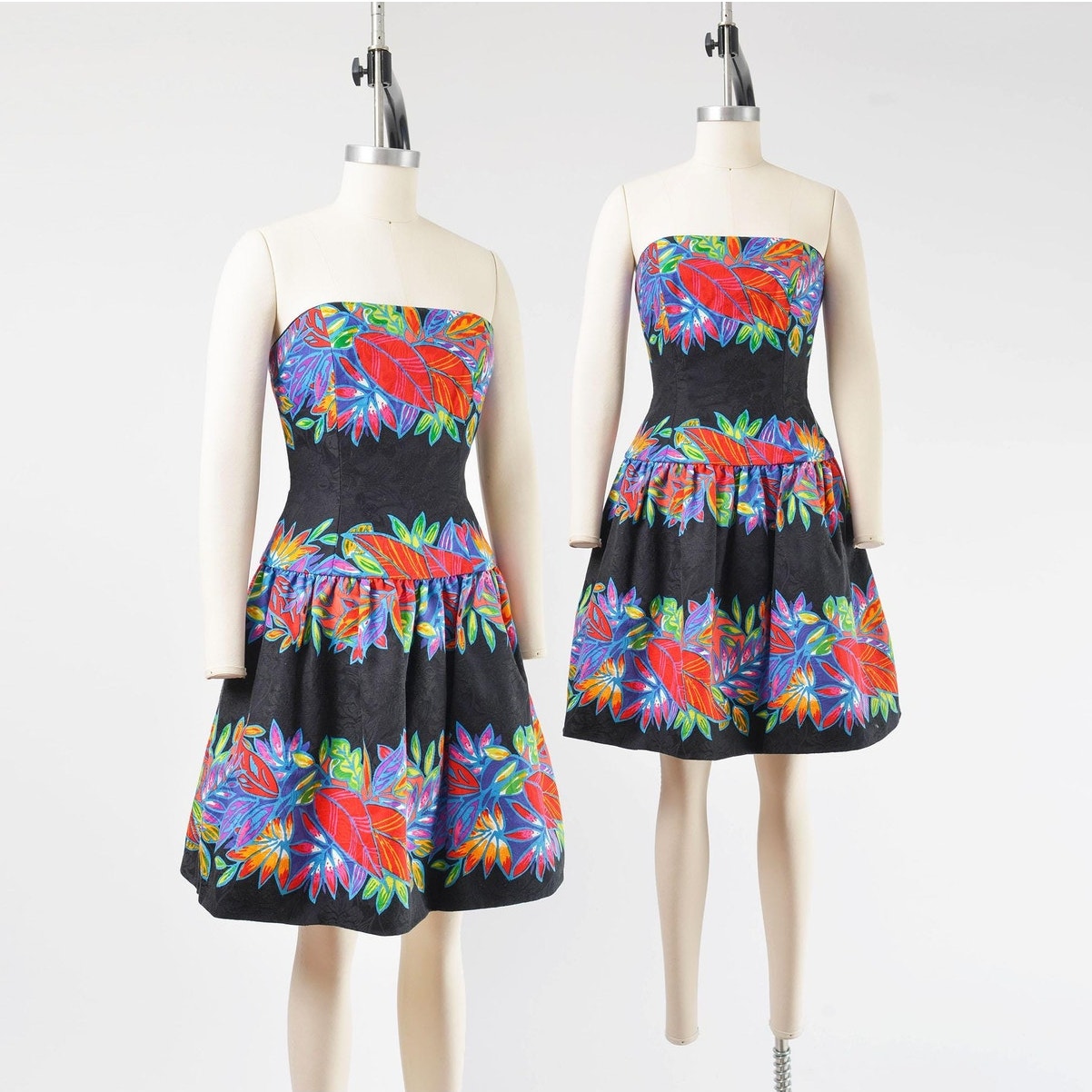 Side by side view of a vintage 1980's tropical leaf print cotton dress. Strapless with drop waist.
