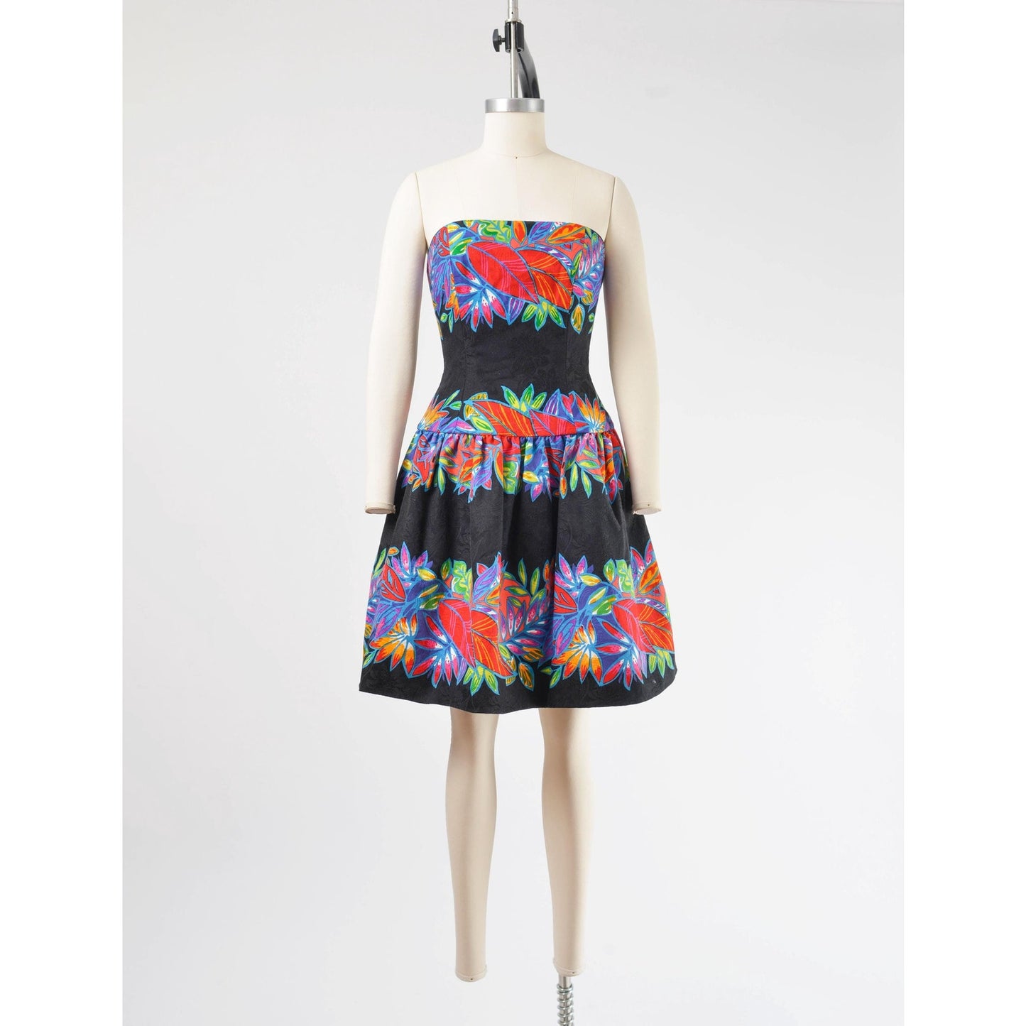 Full front view of a vintage 1980's tropical leaf print cotton dress. Strapless with drop waist.