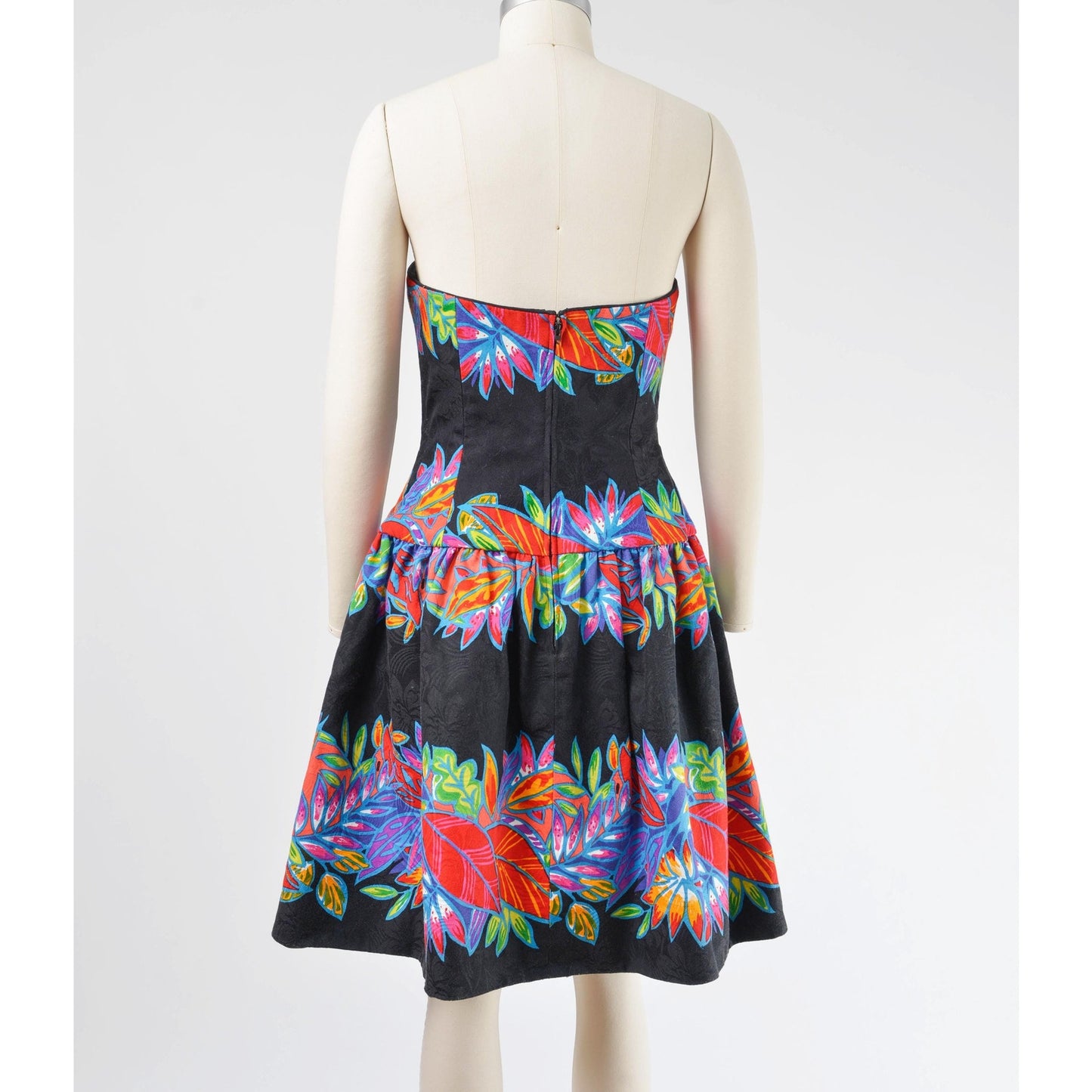 Full back view of a vintage 1980's tropical leaf print cotton dress. Strapless with drop waist.