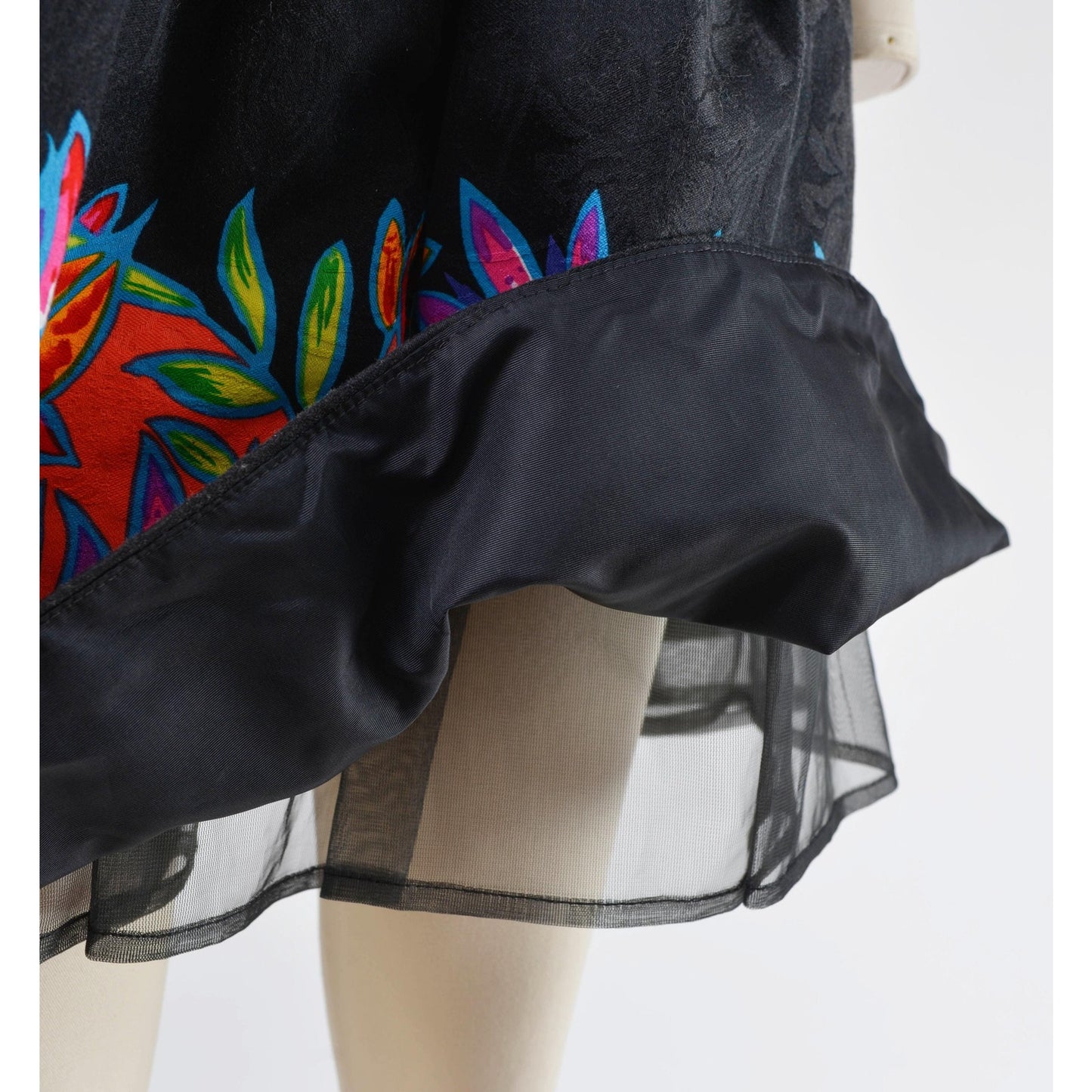 Close up view of tulle underlay on a vintage 1980's tropical leaf print cotton dress. Strapless with drop waist.