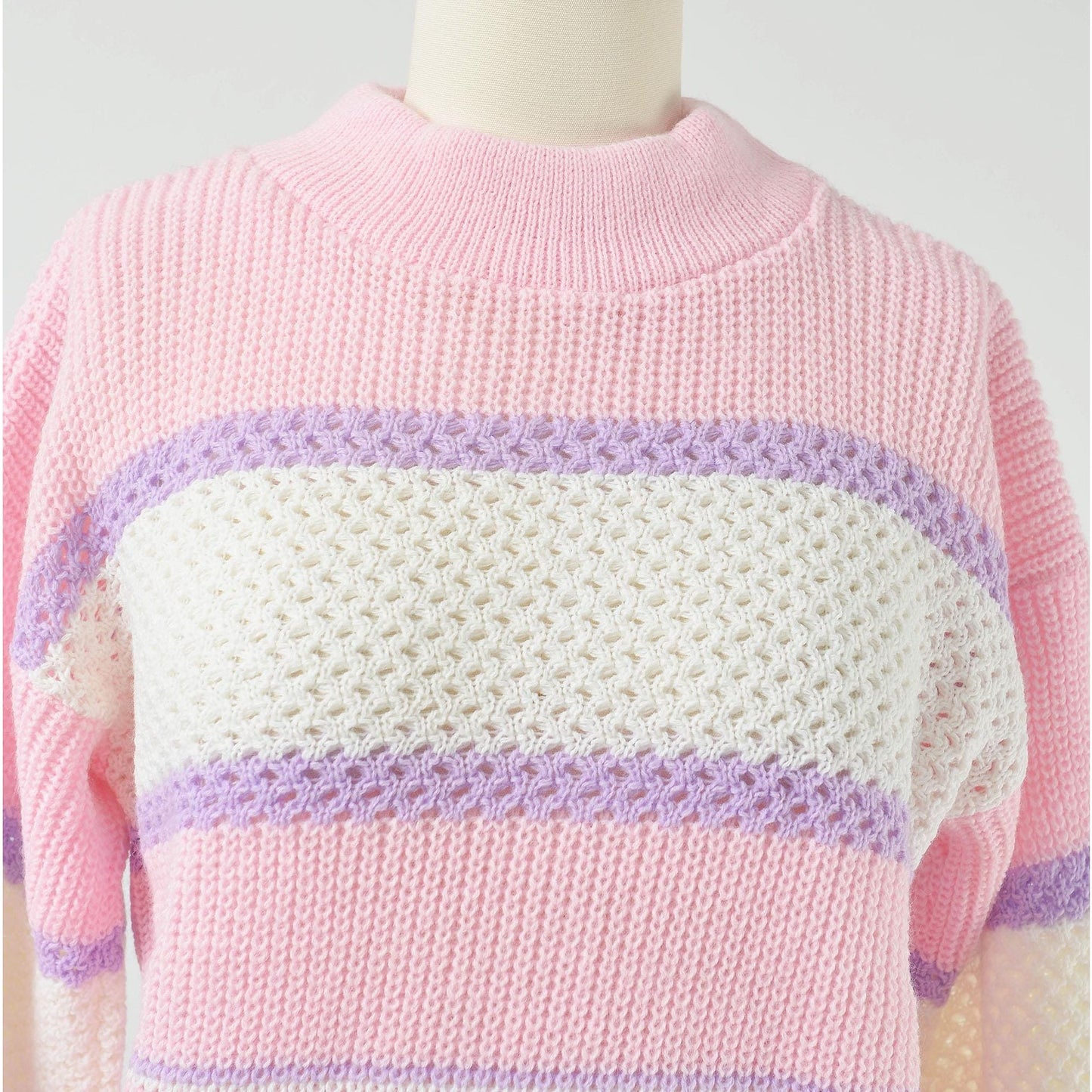 Close up view of neckline on Vintage 1980s pink, white, and purple striped sweater with mock neck and slouchy fit.