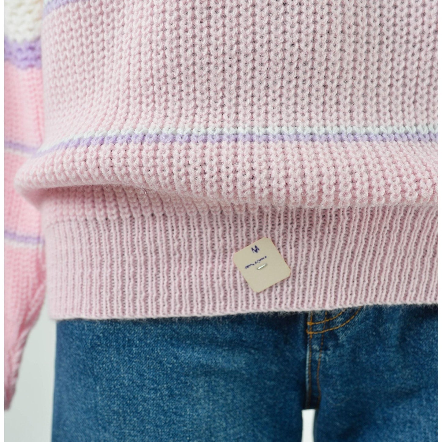 View of tag on Vintage 1980s pink, white, and purple striped sweater with mock neck and slouchy fit.