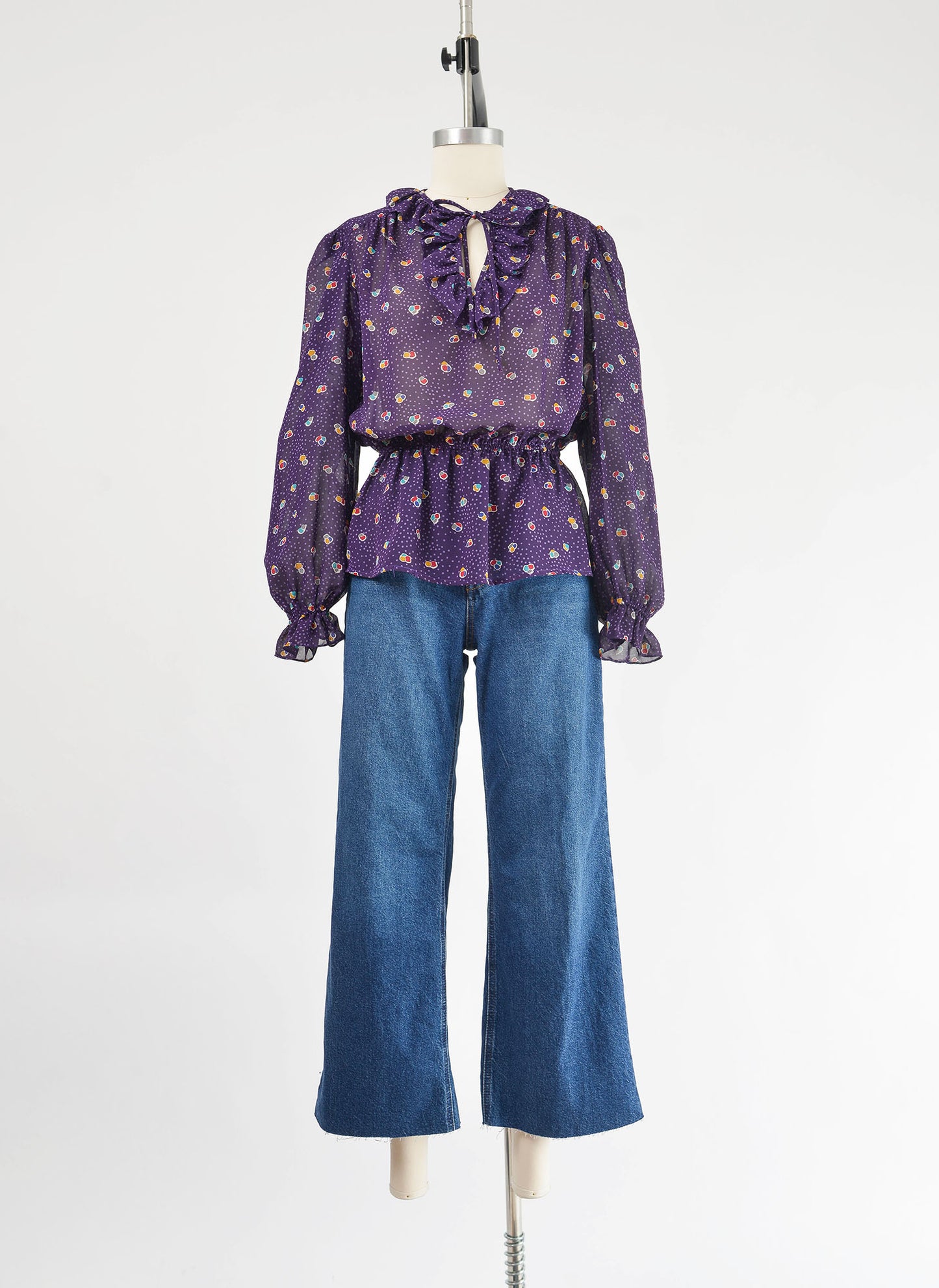 Vintage 80s sheer purple polka dot peplum waist tie neck blouse.