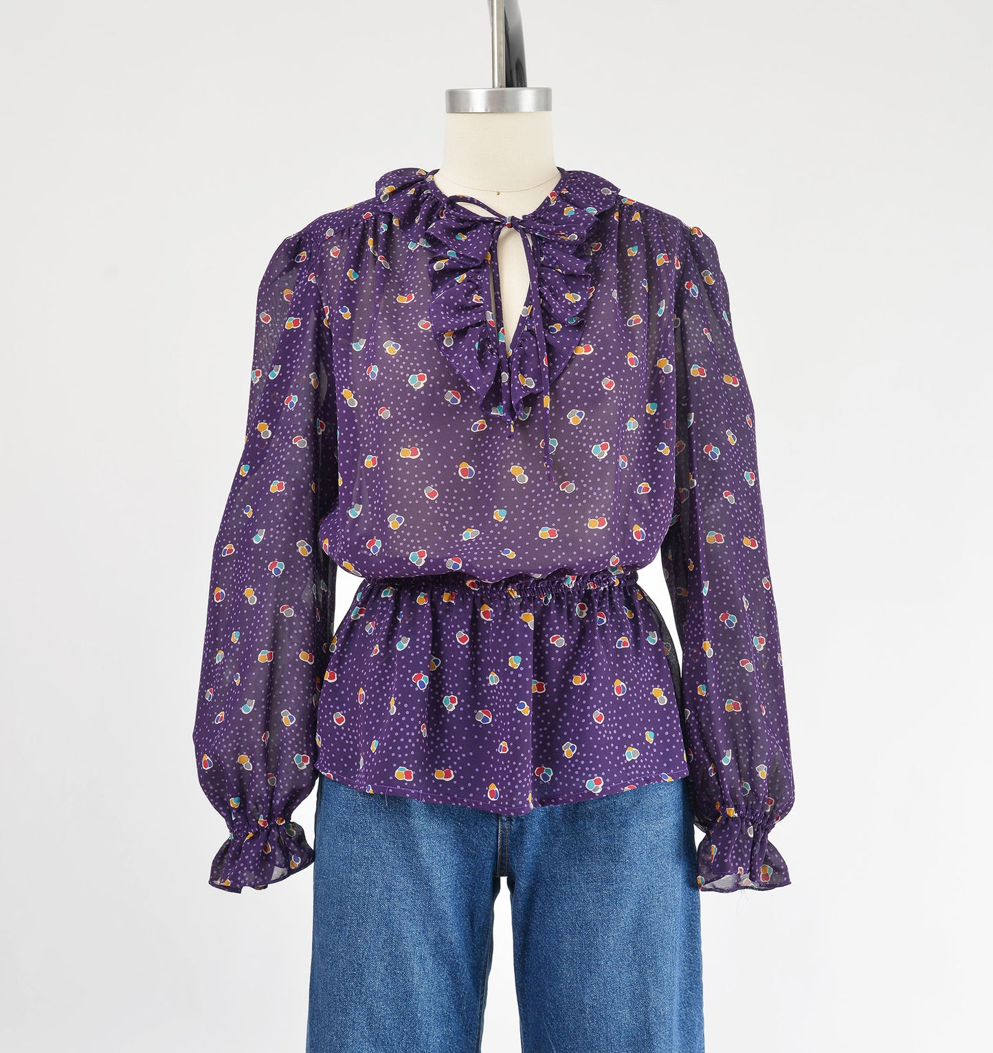 Vintage 80s sheer purple polka dot peplum waist tie neck blouse.