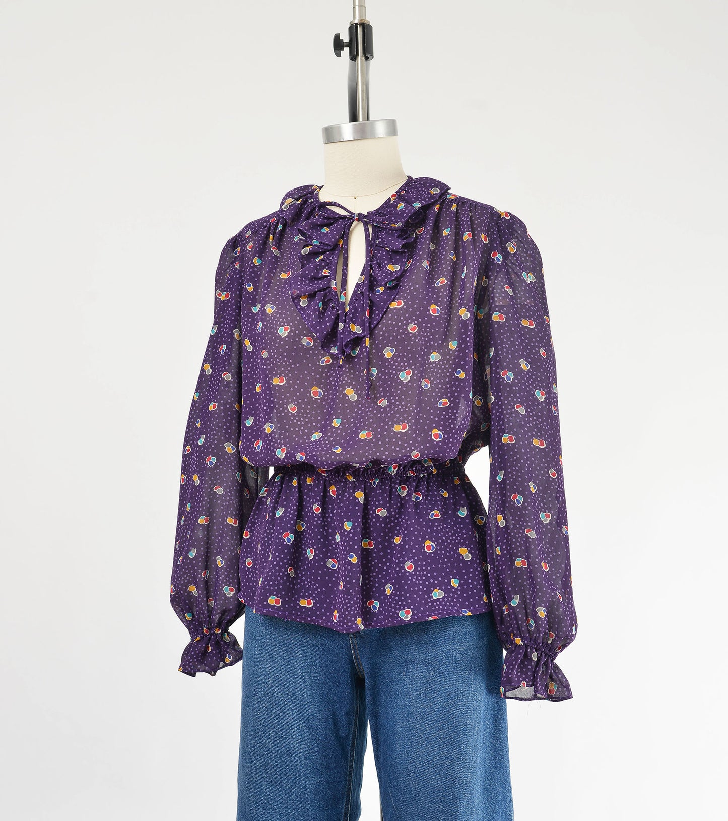 Vintage 80s sheer purple polka dot peplum waist tie neck blouse.