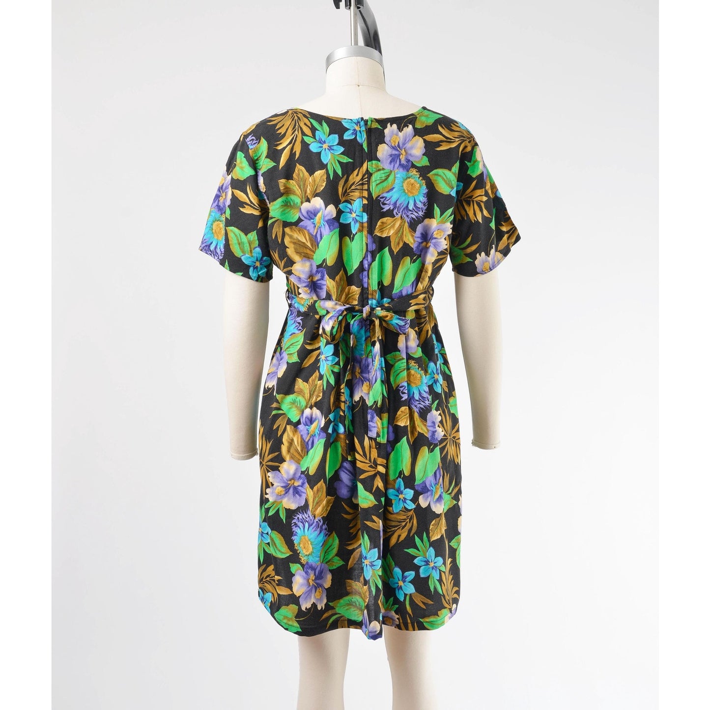 Full back view of vintage 90's floral Hawaiian print babydoll dress. Rear zipper closure with waist ties.