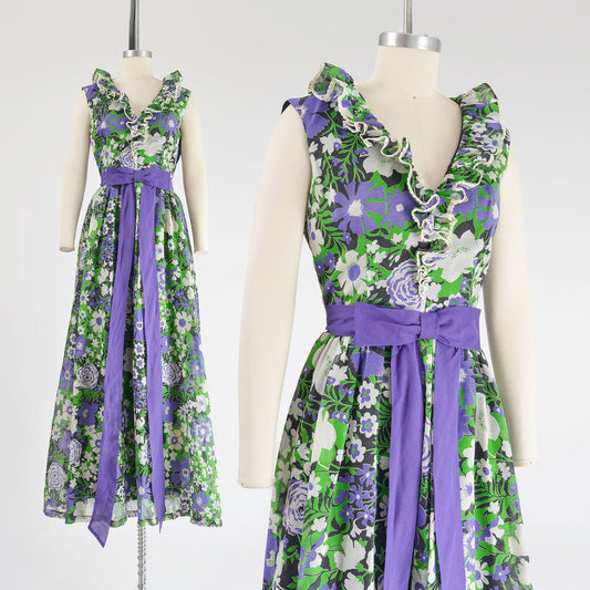 Vintage Miss Elliette floral print maxi dress. Semi sheer cotton fabric. White, green, purple, black, and white print. Ruffle neckline. Purple bow waistline. Full skirt.  