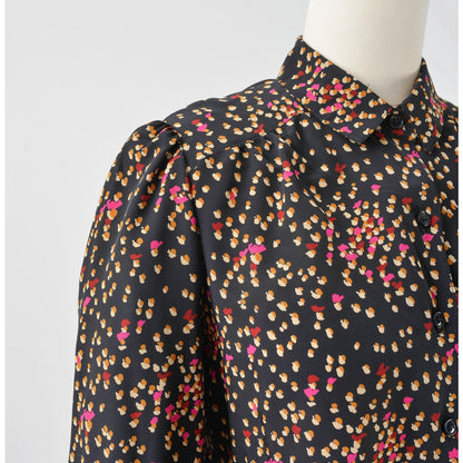 View of shoulder on 70s black spotted blouse. Matte silky fabric. Collared neckline with long puff sleeves. 