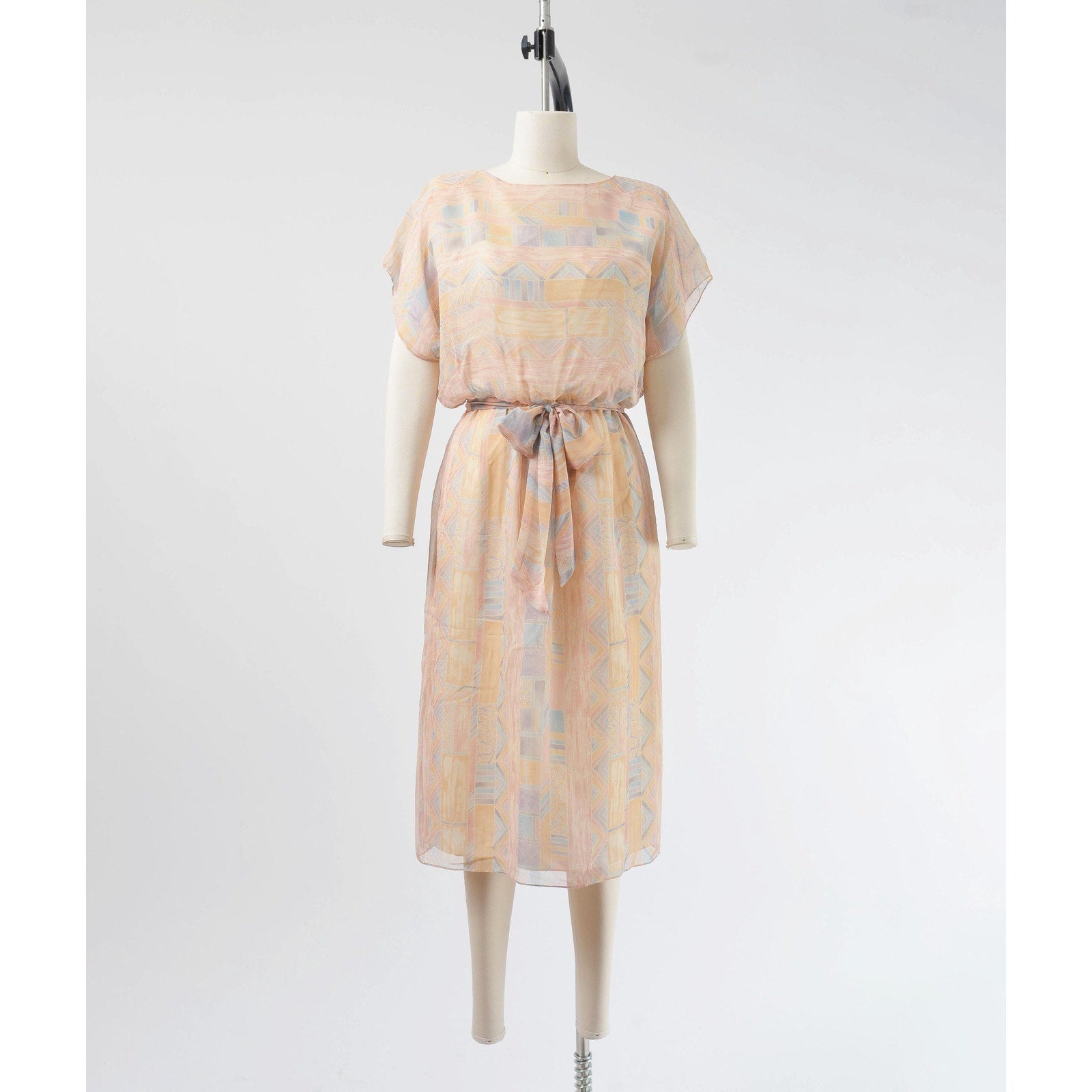 Front view of Vintage 70s pastel geometric sheer chiffon blouson midi dress with tie belt. 