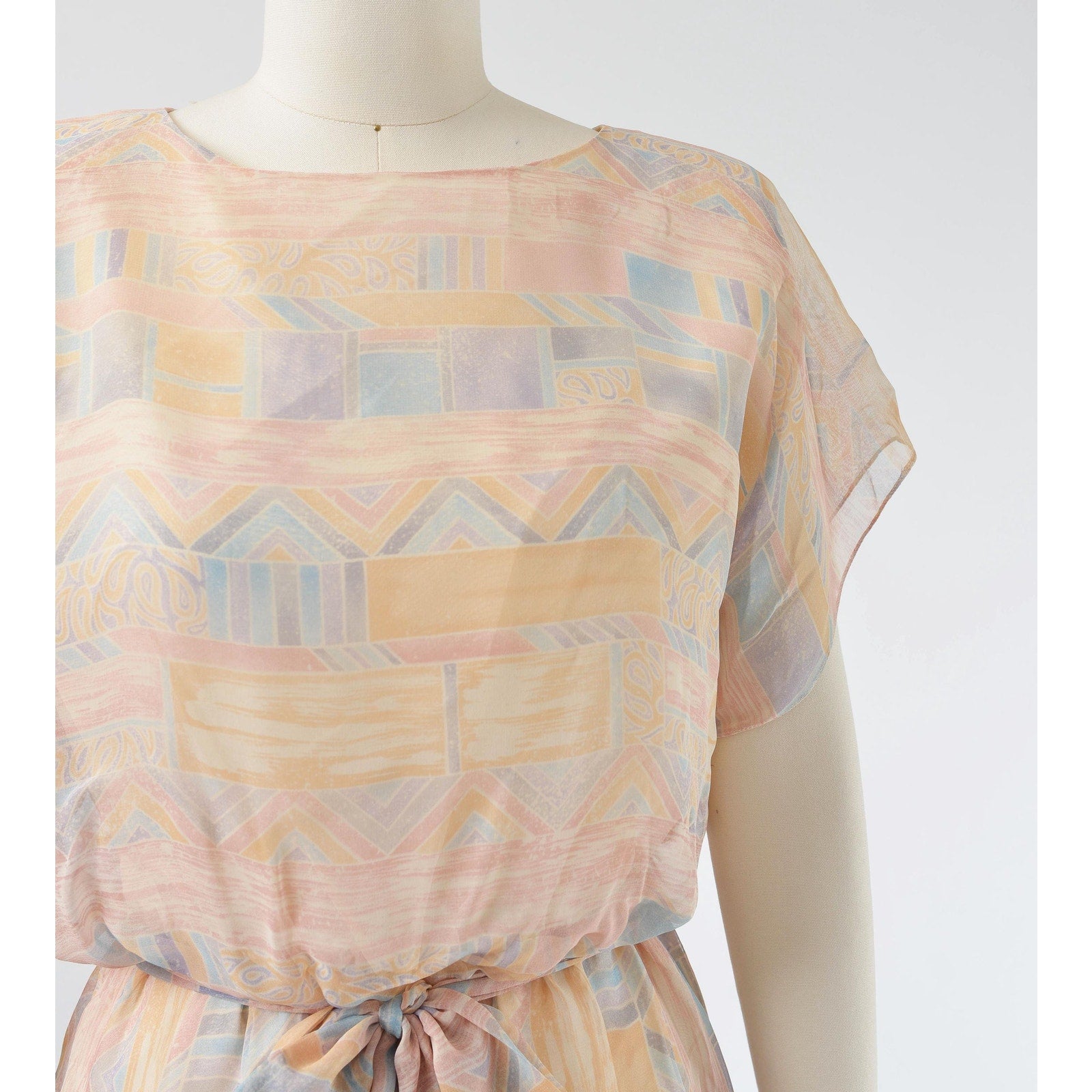 Close up view of fabric on Vintage 70s pastel geometric sheer chiffon blouson midi dress with tie belt. 