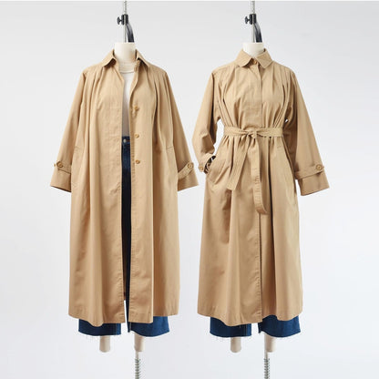 Two side by side views of a vintage 1970's tan trench coat with tie belt. 