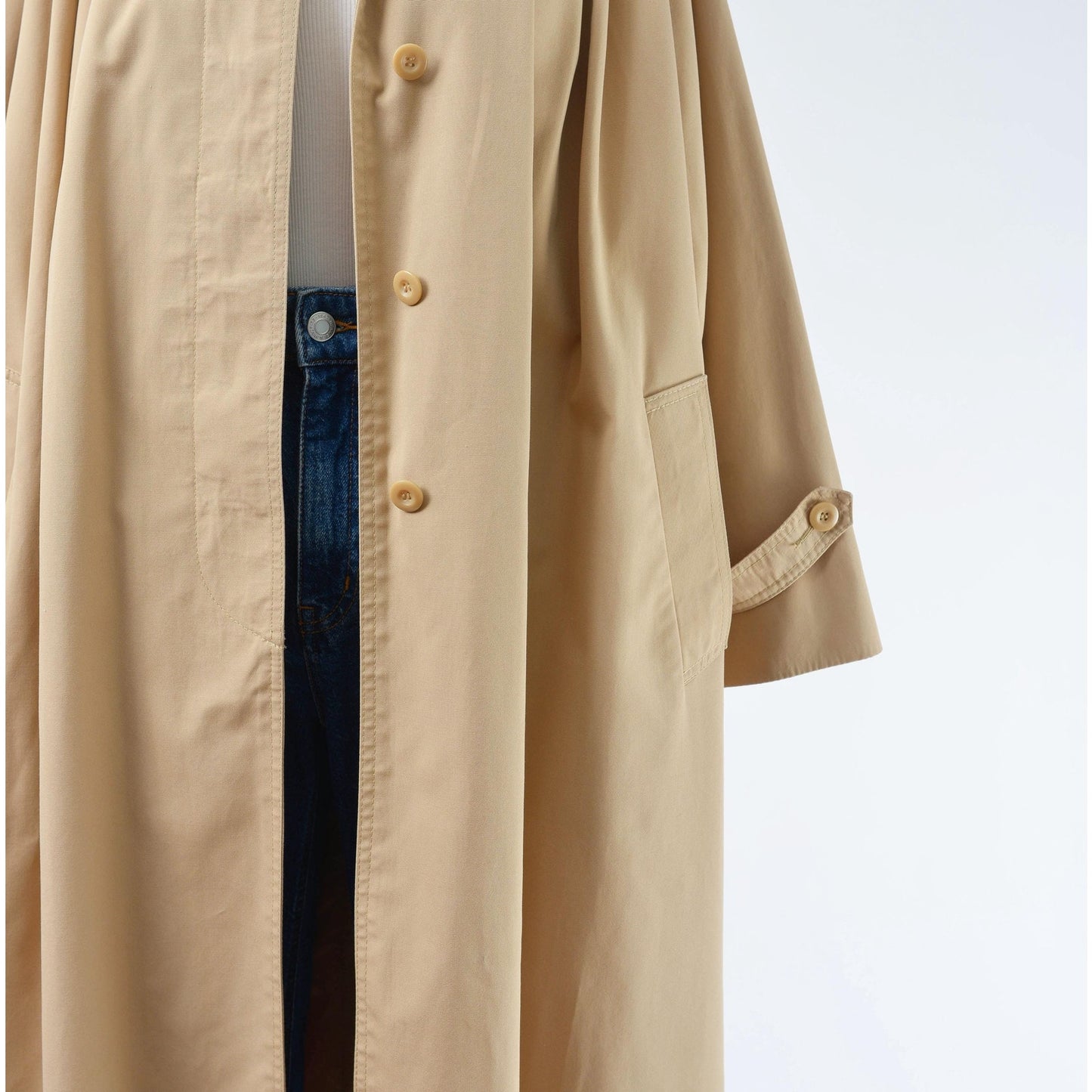 Close up view of waistline on a 70's tan trench coat. 
