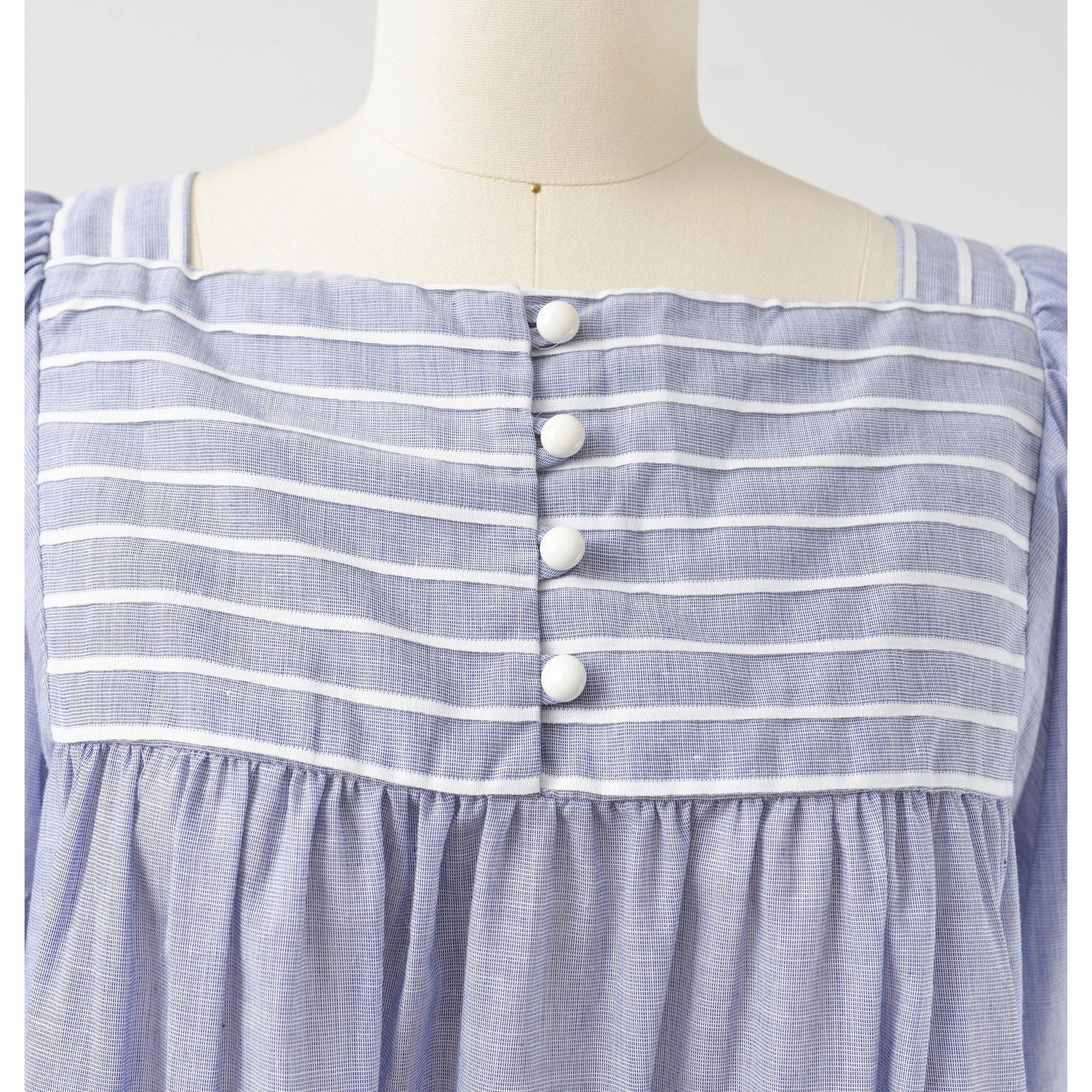 Button closures down neckline on 80s blue and white striped cotton tent dress with puff sleeves. Front view. 