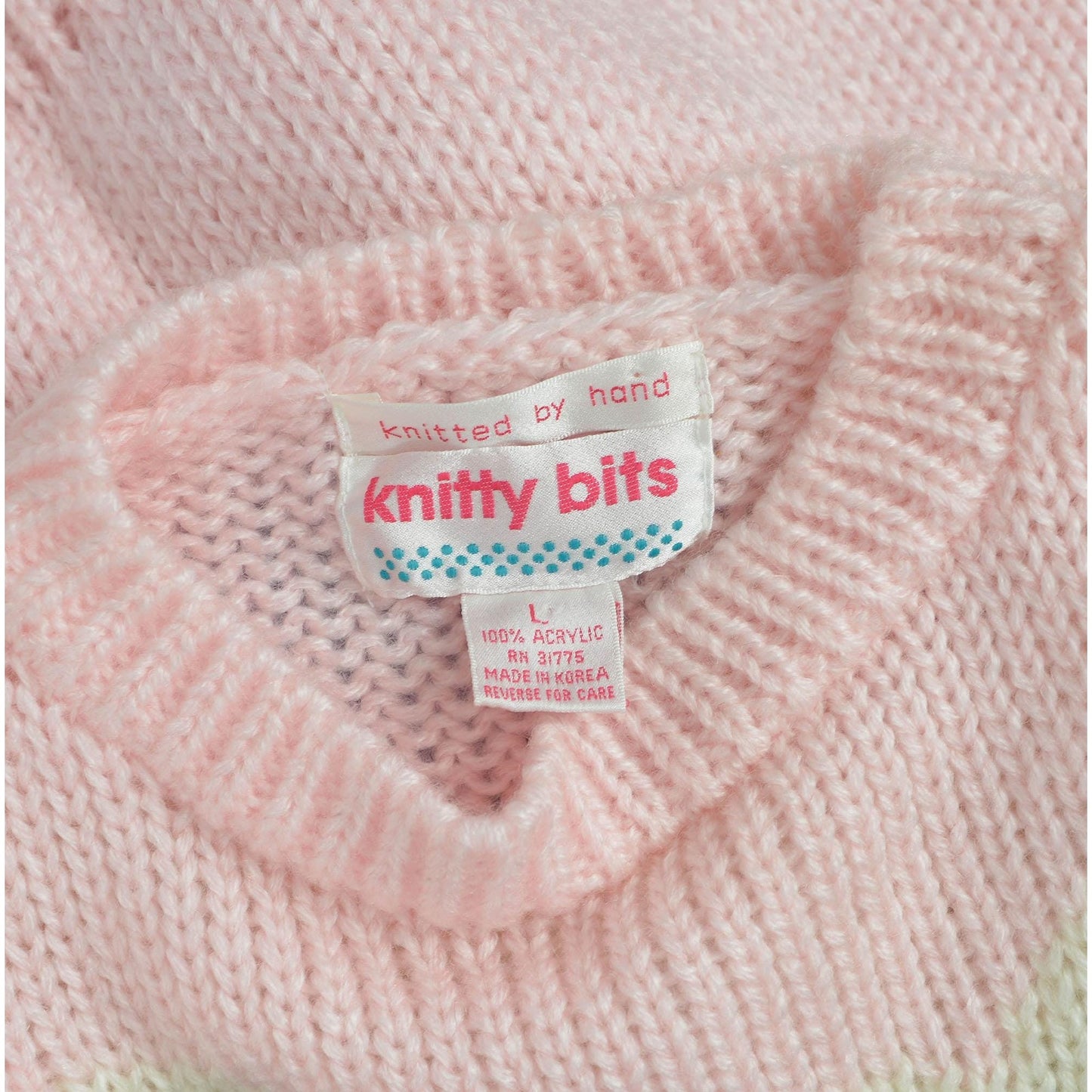 View of label Knitty Bits. Vintage 1980s kawaii pink teddy bear sweater. Chunky acrylic knit. 