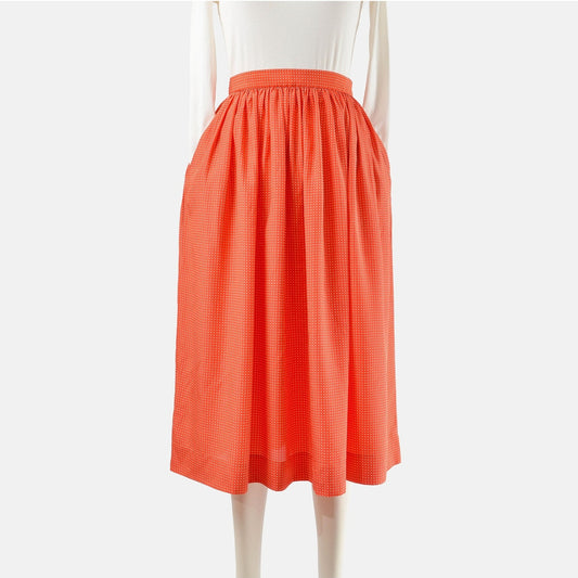 Front view of a 80s vintage orange and white polka dot full midi skirt. 