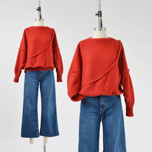 A vintage 1980s red batwing mohair blend knit top with slouchy sleeves and a slit neckline, displayed on a mannequin with a pair of blue jeans.