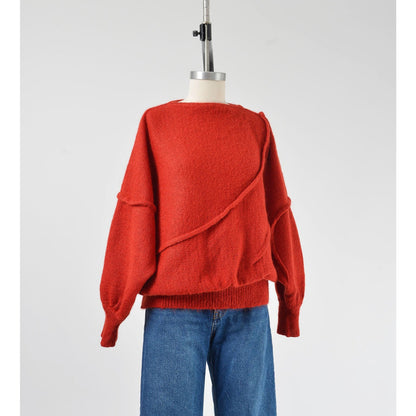 A vintage 1980s red batwing mohair blend knit top with slouchy sleeves and a slit neckline, displayed on a mannequin with a pair of blue jeans.