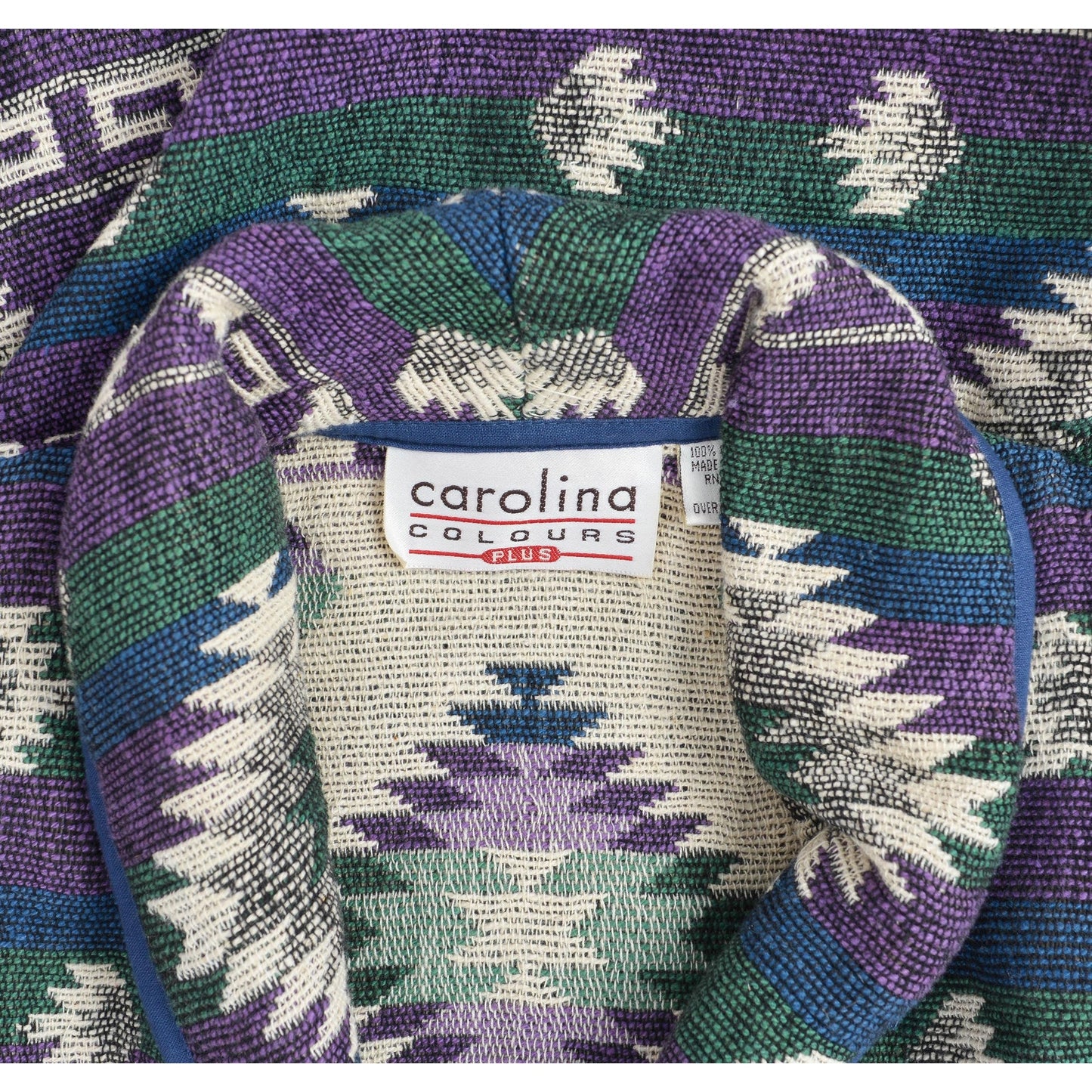 Close-up of a woven fabric with a Carolina Colours Petie brand label in the center.